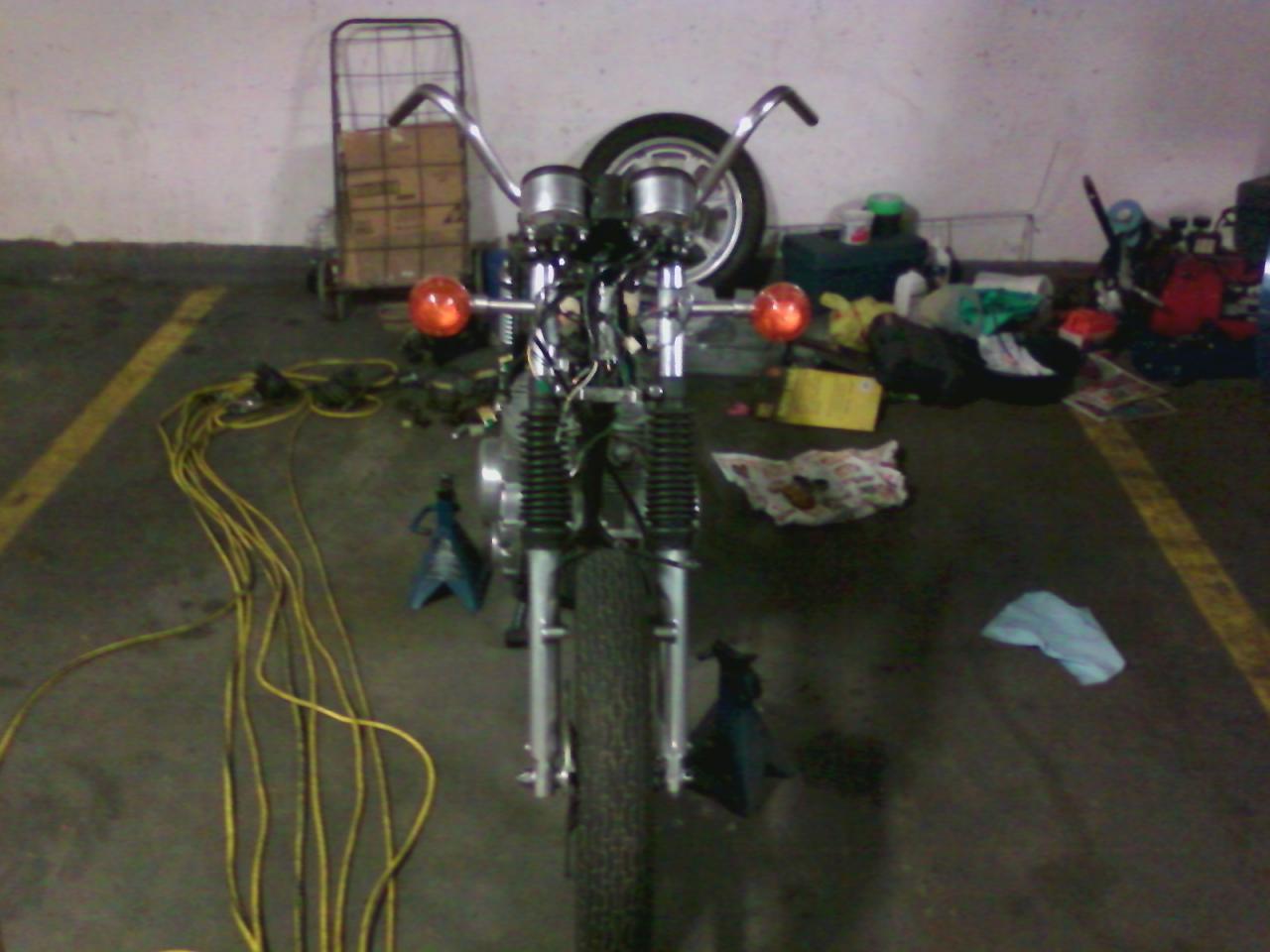 view from the front with it all straightened out and the signal lights mounted and the handlebars on. Fork gaitors in place. Front fender is off on va